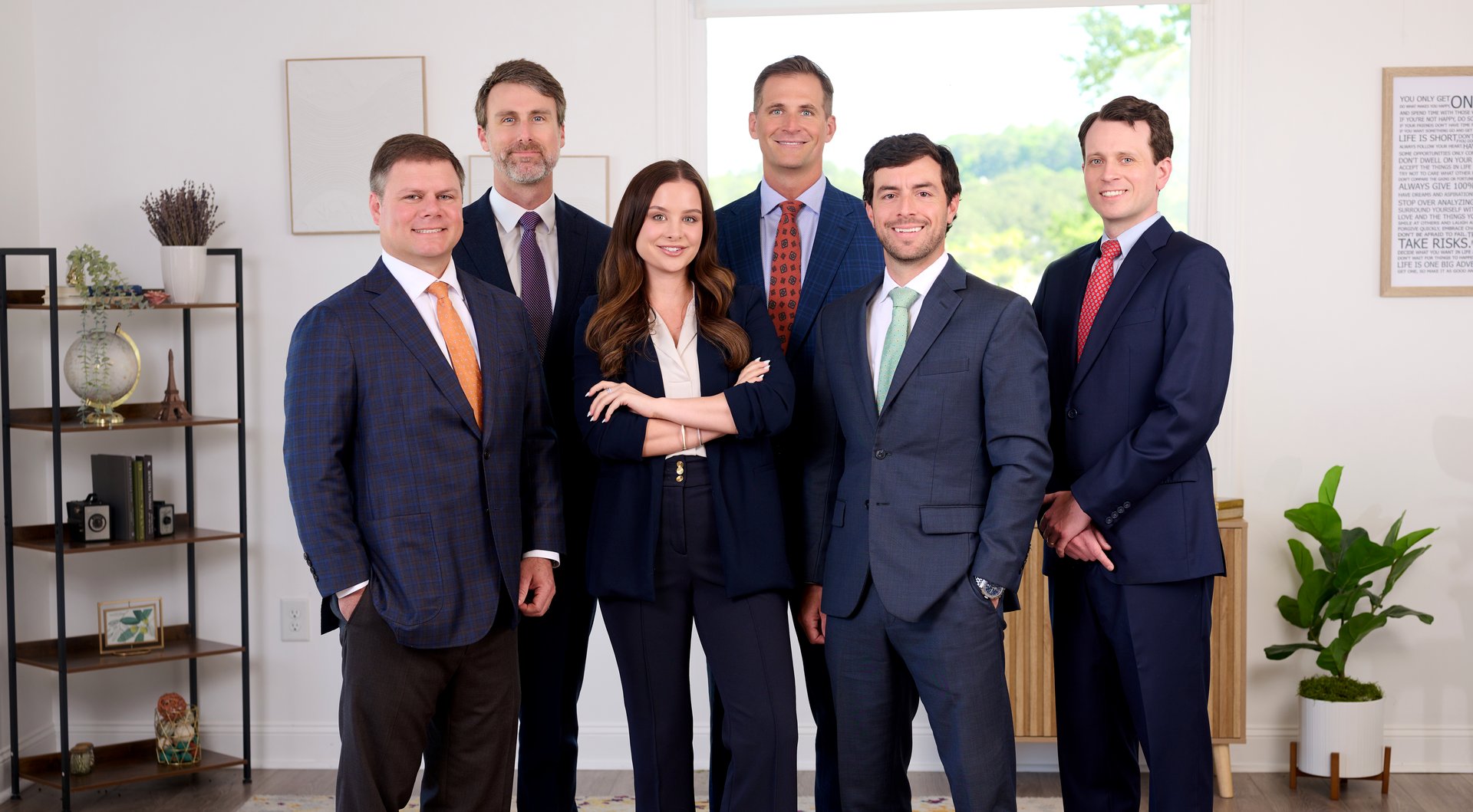 Six Bodewell Injury Group attorneys standing together in the firm’s office
