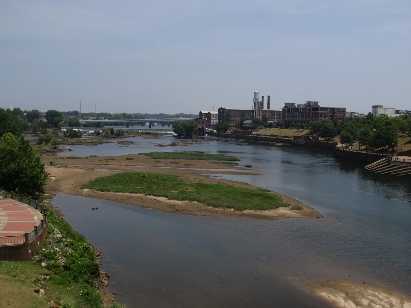 Chattahoochee River between Phenix City and Columbus, with riverside buildings and a bridge in the distance.